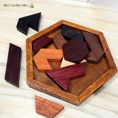 Casse tete puzzle en bois avec des pièces multicolores dans un plateau hexagonal, quelques pièces à côté.