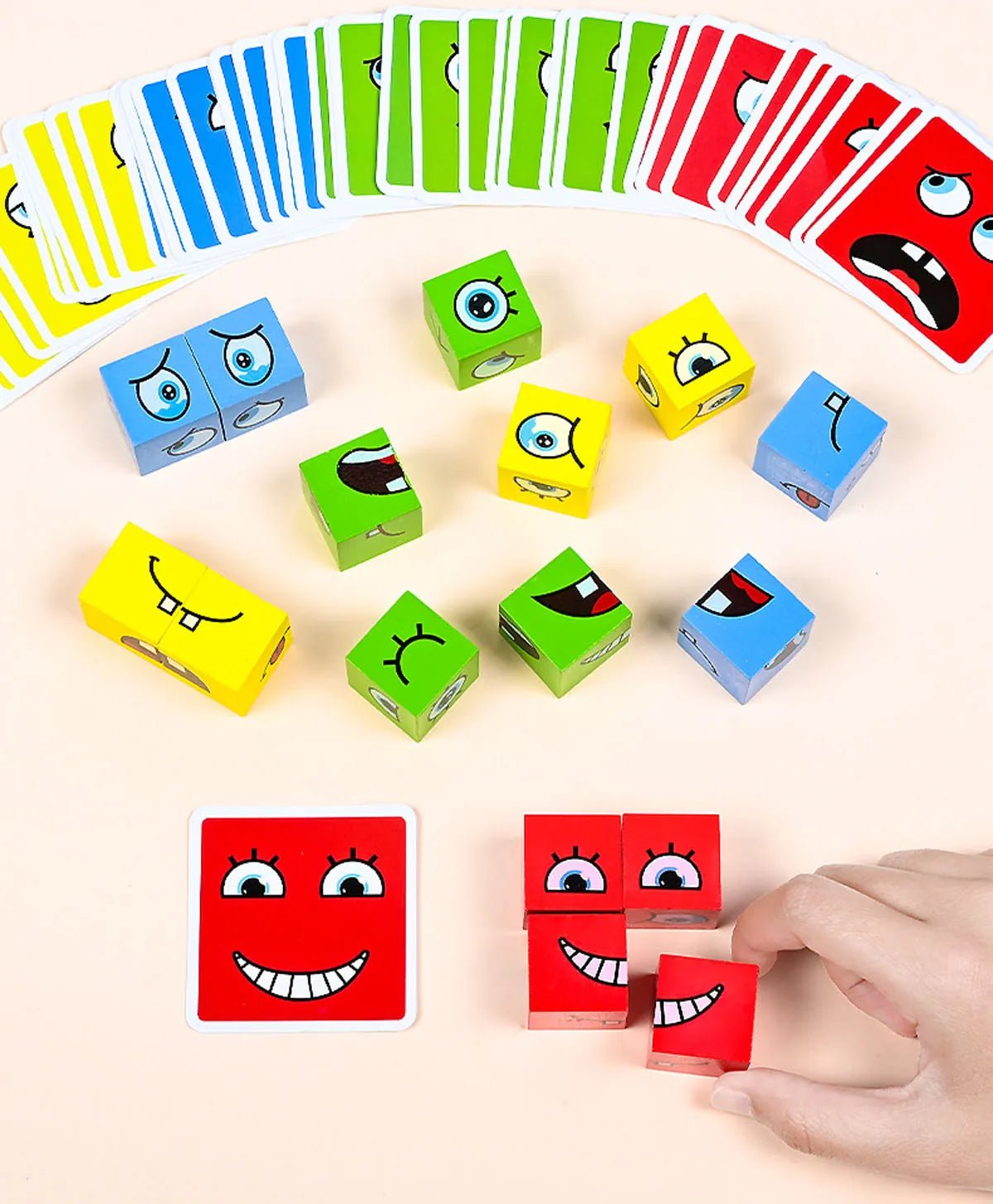 Cubes et cartes colorés avec visages expressifs, main assemblant des cubes rouges.