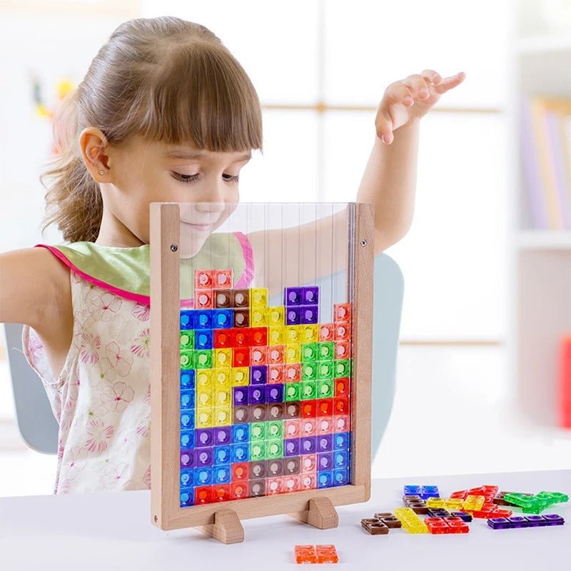 Petite fille joue avec des blocs colorés empilés dans un cadre en bois, concentrée et souriante.